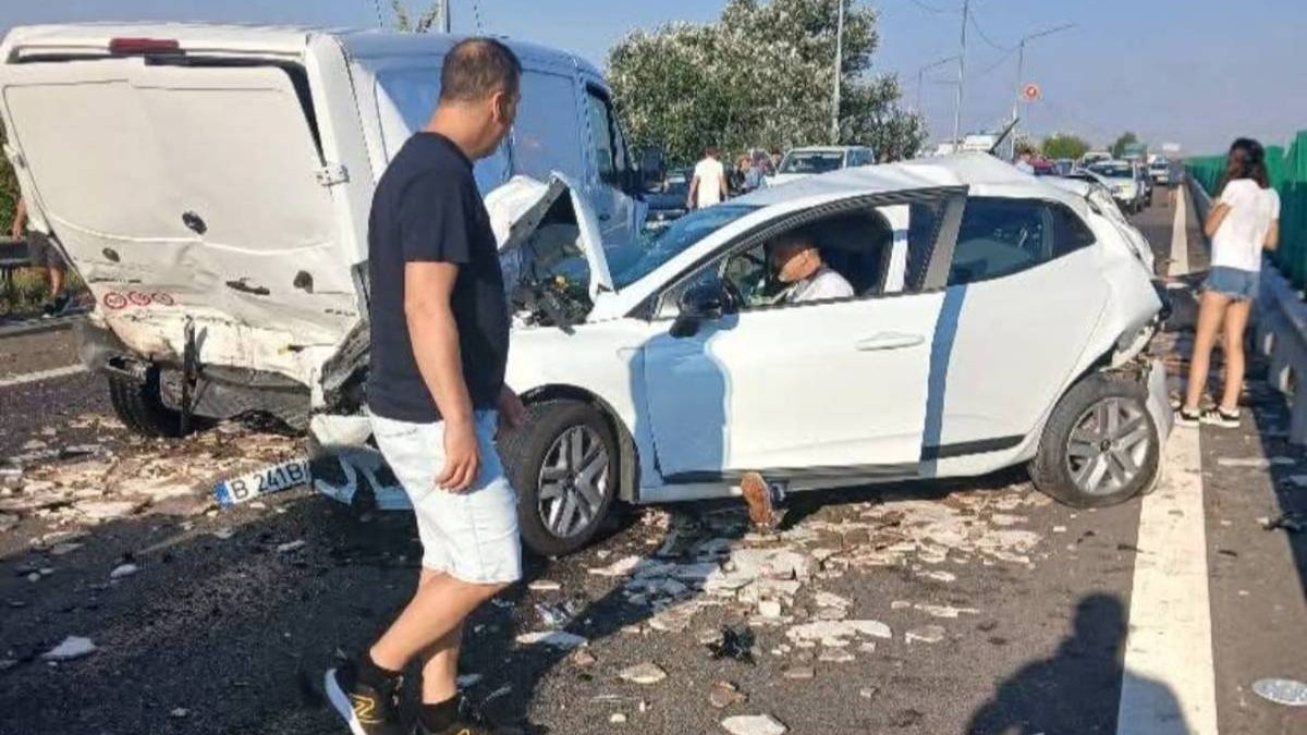 Imagine cu doi oameni aflați în apropierea unei mașini și a unei dube albe care au fost implicate în accidentul petrecut pe A2, pe sensul spre Constanța. Un bărbat se află în autoturismul alb implicate în accident