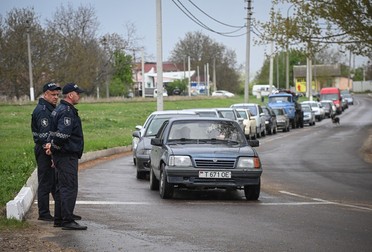Polițiști moldoveni, lângă o coadă de mașini, la ieșirea din Republica separatistă Credit line: Profimedia