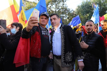 Un participant la manifestație își face un selfie cu George Simion