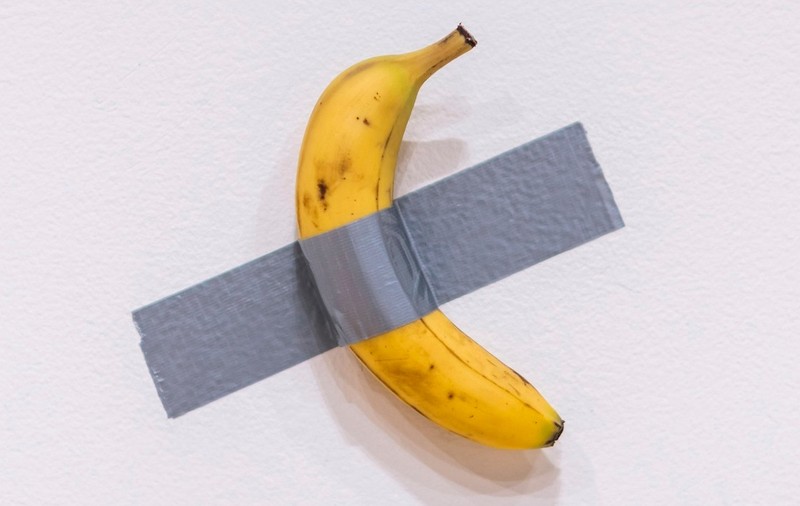 O banană lipită cu bandă adezivă de un perete alb, o instalație a artistului Maurizio Cattelan, a fost vândută la licitație pentru 6,2 milioane de dolari