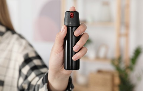 O femeie care ține în mână un spray cu piper