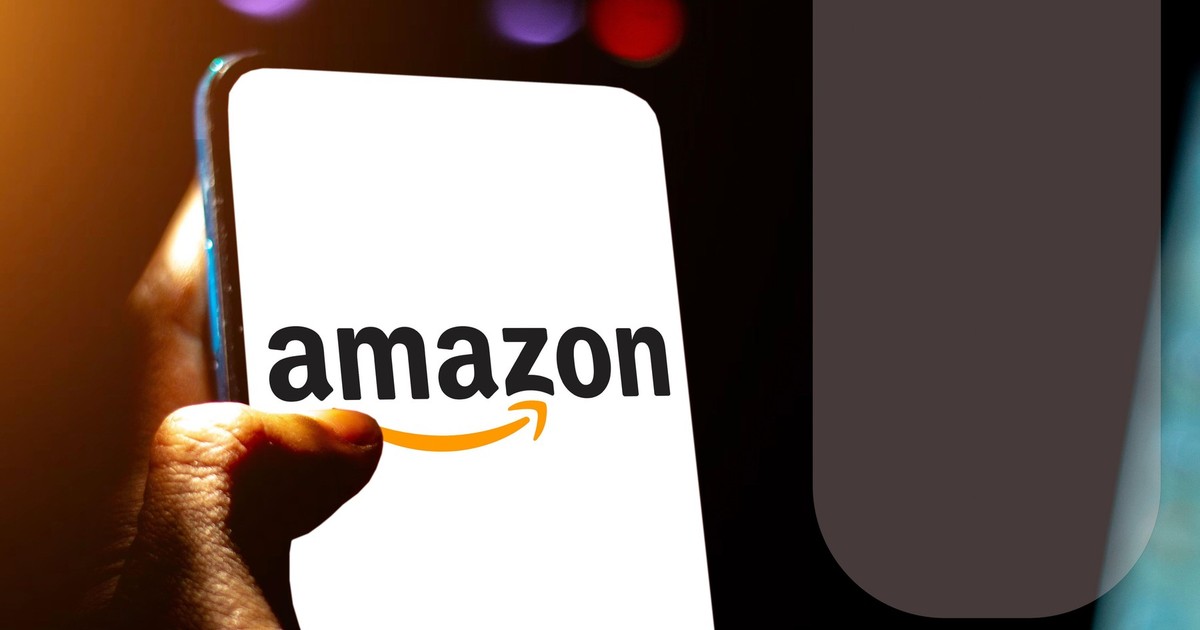 Ecranul unui telefon mobil pe care este afișat logo-ul Amazon. Dispozitivul este ținut în mână de un bărbat