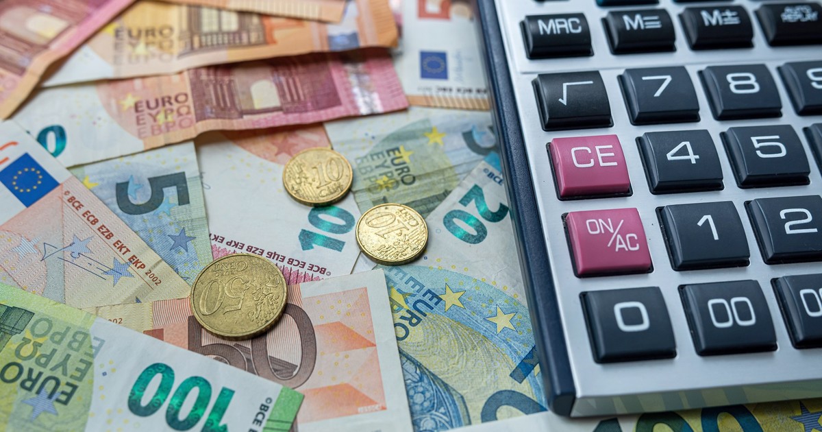 monede și bancnote de euro puse pe o suprafață, un calculator în partea dreaptă