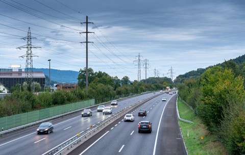 O autostradă din Elveția, în timp ce mai multe mașini trec pe toate cele patru benzi prin fața unor aparate radar și indicatoare rutiere