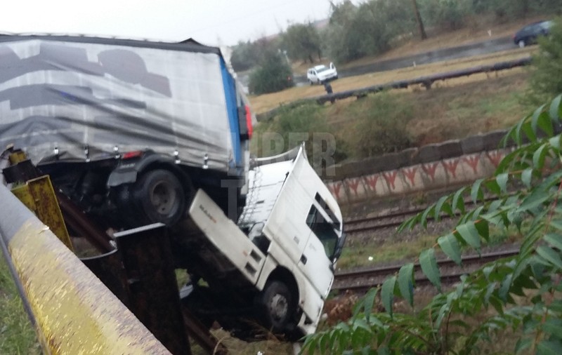 Un Tir a rămas suspendat pe pod, deasupra unei linii de tren