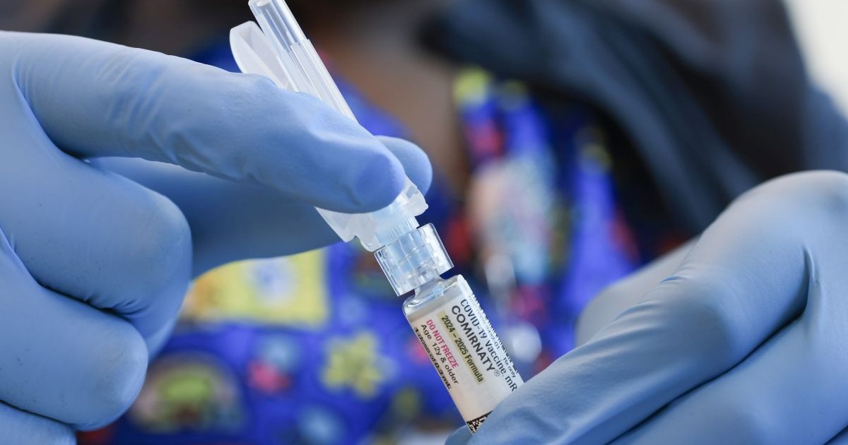 Asistentă medicală specializată în imunizări ține în mână un vaccin Pfizer-BioNTech COVID-19, 29 mai 2025