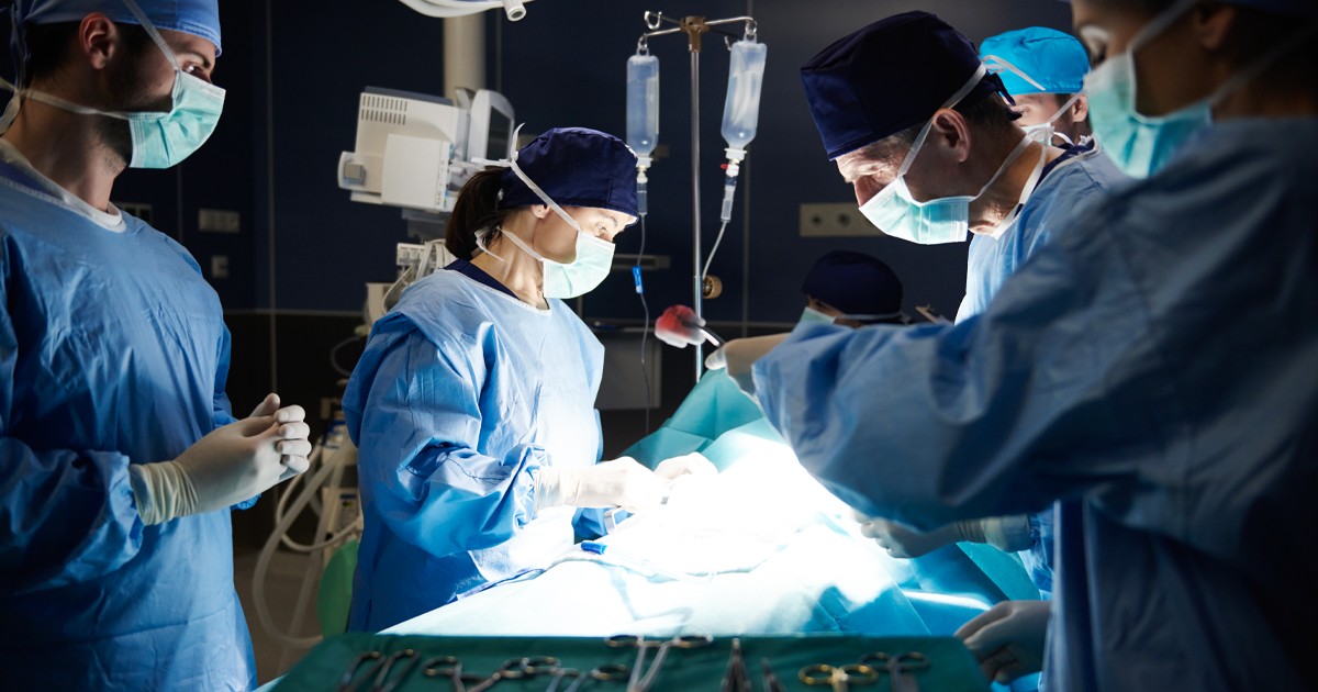 Doctorii în sala de operație, echipați cu halate si echipament corespunzător realizează o intervenție chirurgicală.