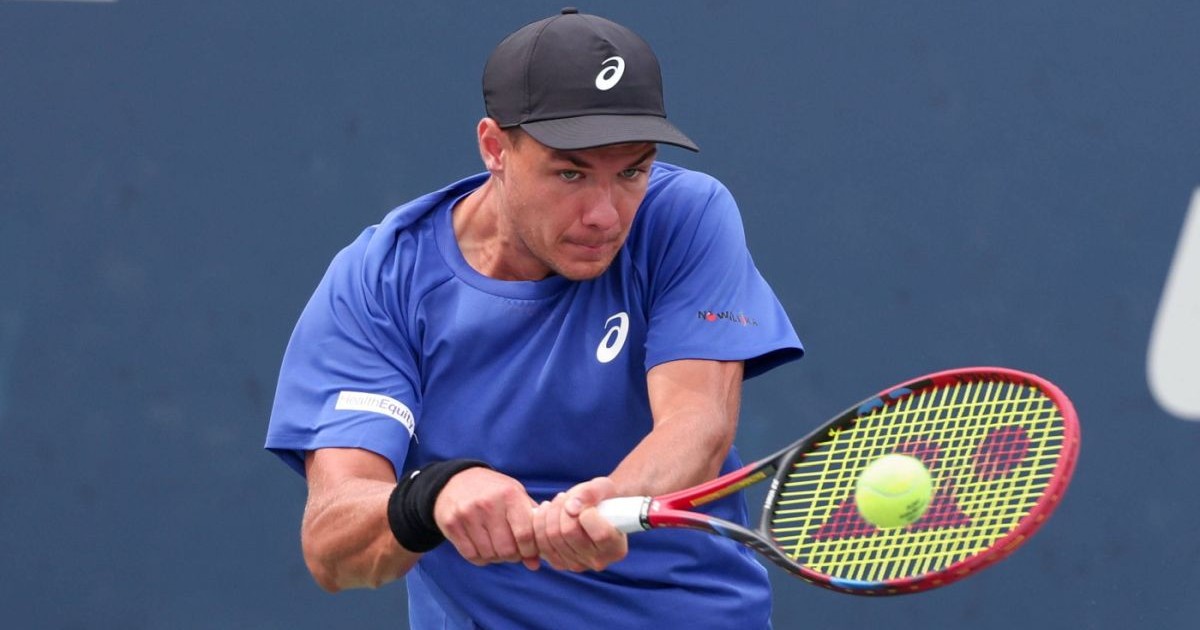 Kamil Majchrzak, cu o șapcă neagră pe cap și în tricou albastru, returnează o minge în timpul unui meci de la US Open, august 2025