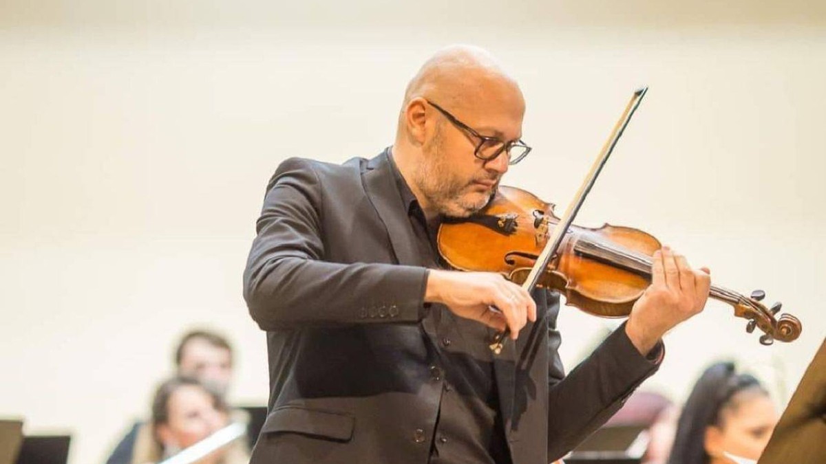 Mădălin Sandu cântă la vioară, în timpul unui concert.