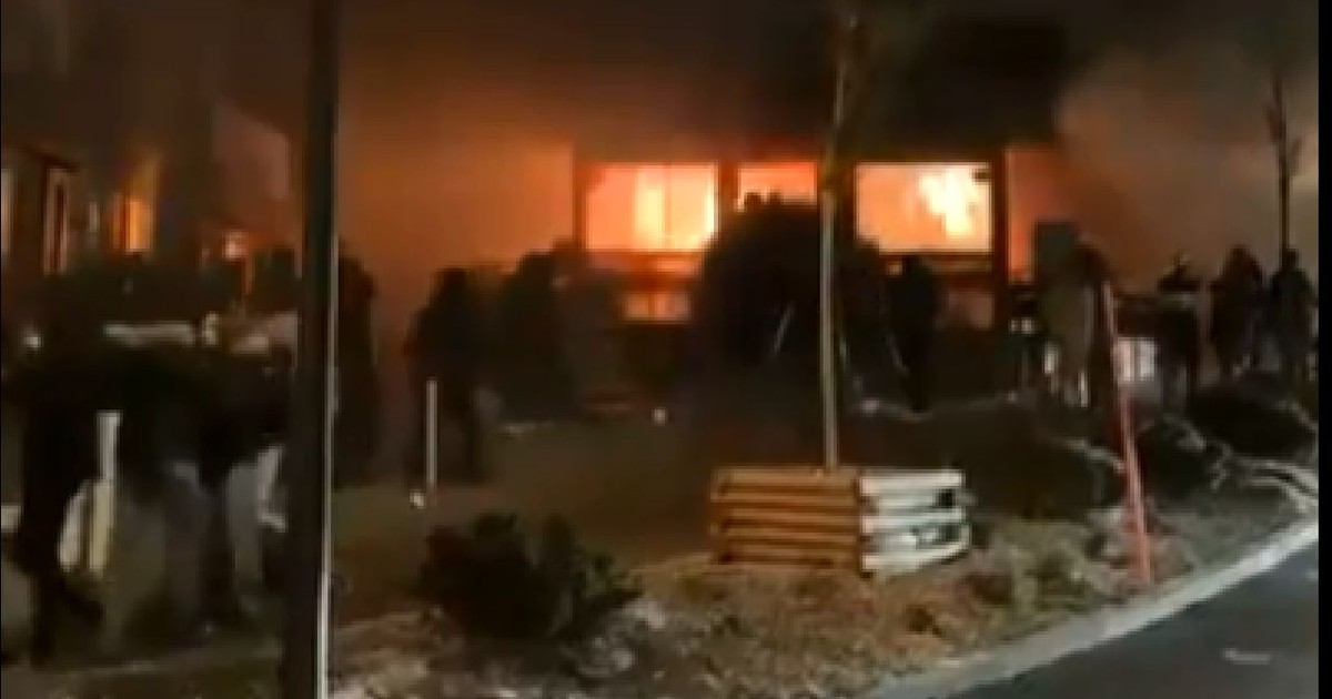 Imagine de noapte cu un local in flacari, se vede o strada pustie, un bar care arde cu flacari uriase