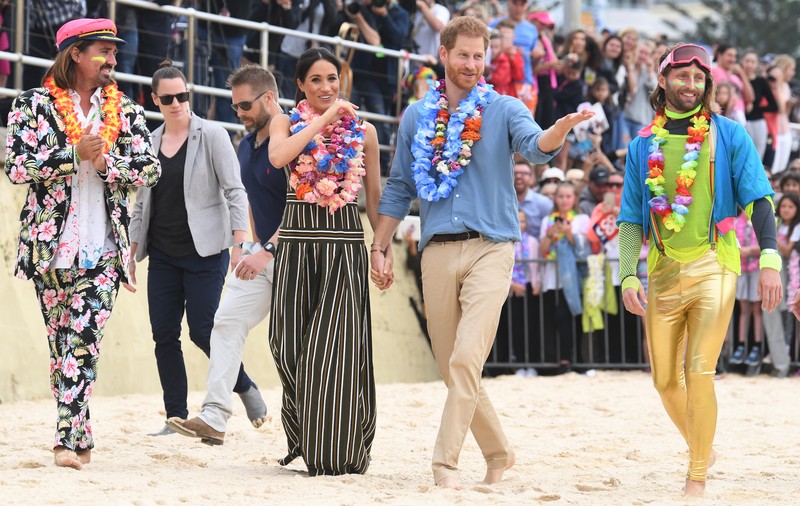 FOTO | Prințul Harry și Meghan Markle s-au descălțat pe o plajă din Australia. Oamenii au fost surprinși de gestul cuplului regal