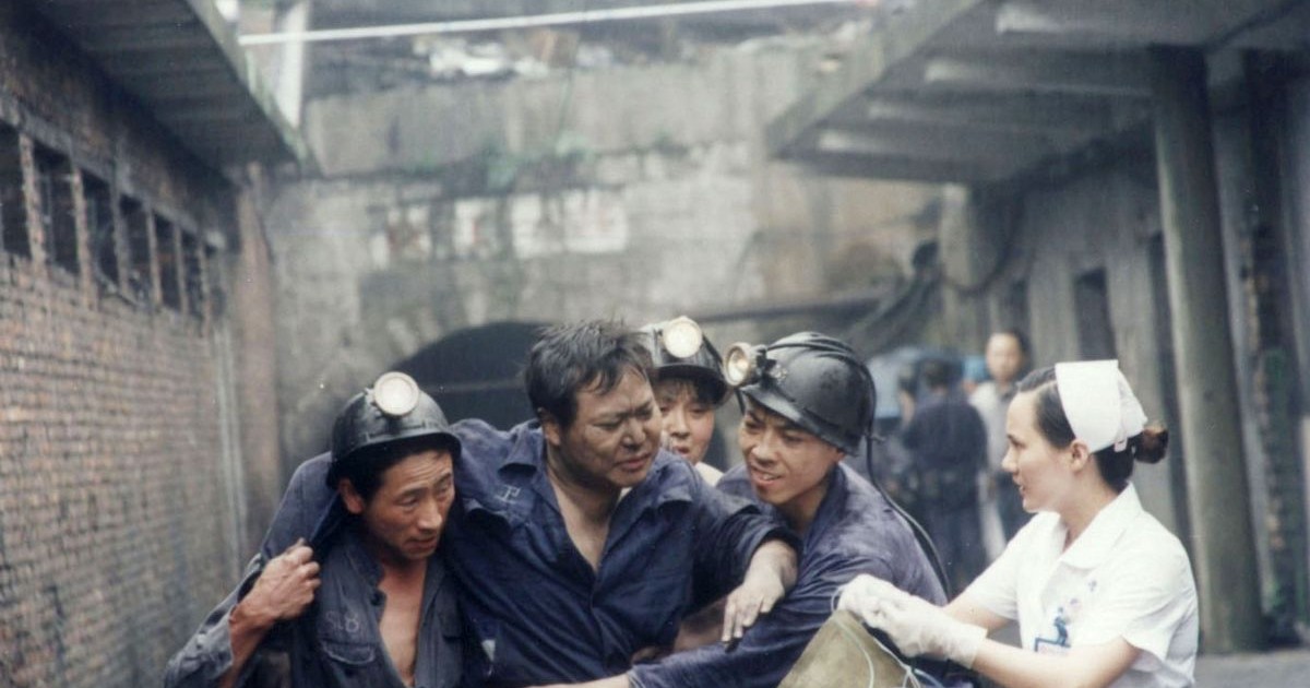 Salvatorii chinezi sprijină un miner rănit în timp ce este evacuat dintr-o mină după o scurgere de gaze la mina de cărbune Zijiang, pe 8 iunie 2005, în Loudi, provincia Hunan, sudul Chinei.