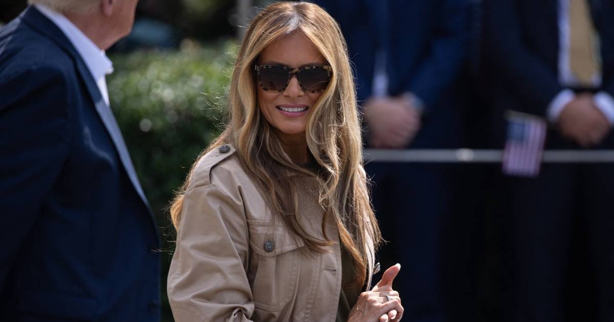Melania Trump la Casa Albă, în timp ce merge către elicopte. Poartă o jachetă maro și ochelari mari de soare la ochi