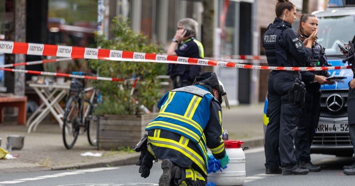 Ofițeri de poliție patrulează în fața unei cafenele din Bochum, unde mai multe persoane au fost rănite într-un atac cu un lichid acid, 30 iunie 2024