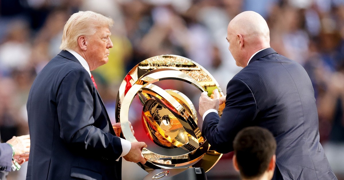 Donald Trump (în stânga) și Gianni Infantino (în dreapta) surprinși în timp ce țin în mâini trofeul Club World Cup- iulie 2025