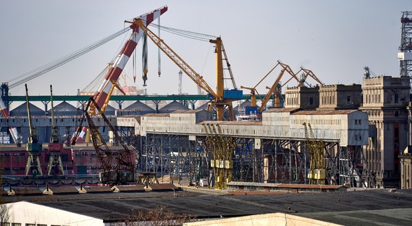 Imagine din Portul Constanța, acolo unde se vedem cum macaralele încarcă mai multe containere pe o navă cargo