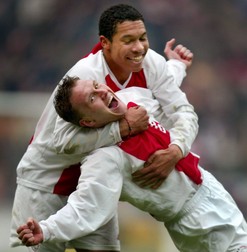 epa00131498 Nigel de Jong of Ajax Amsterdam (L) hugs his teammate Nicolae Mitea, who scored the winning goal against PSV Eindhoven during their Dutch Premier League soccer match in Amsterdam, Sunday 08 February 2004. Ajax won 2-1. EPA/OLAF KRAAK