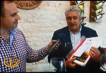 Momentul în care producătorul de vinuri Gheorghe Albu îi spune prezentatorului Viorel Popescu (stânga) că ar avea ceritficate de virginitatea ale fetelor care zdrobesc strugurii