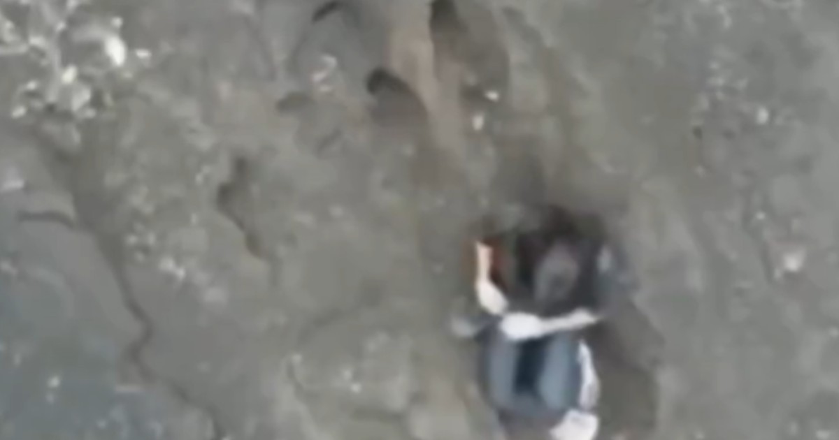 O femeie căzută într-un vulcan din Indonezia, surprinsă într-o poziție ghemuită.