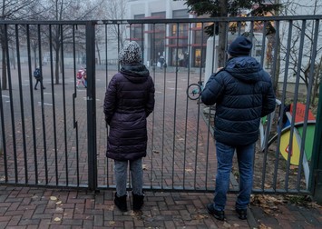 Părinții își privesc copiii prin gardul școlii | Foto: Vlad Chirea