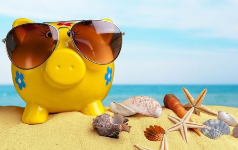 O pușculiță de culoare galben strălucitor, care poartă ochelari de soare, stă pe o plajă, înconjurată de scoici și stele de mare - vacanță bani