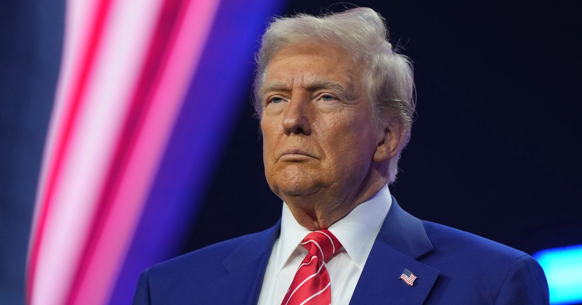 Donald Trump, îmbrăcat în costum, cu cravată roșie