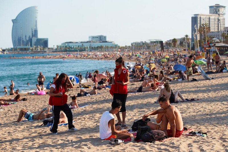 Voluntarii Crucii Roșii spaniole merg pe plajă pentru a le reaminti tinerilor să respecte regulile de prevenție COVID FOTO: EPA