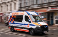 O ambulanță care circulă cu viteză pe șosea.