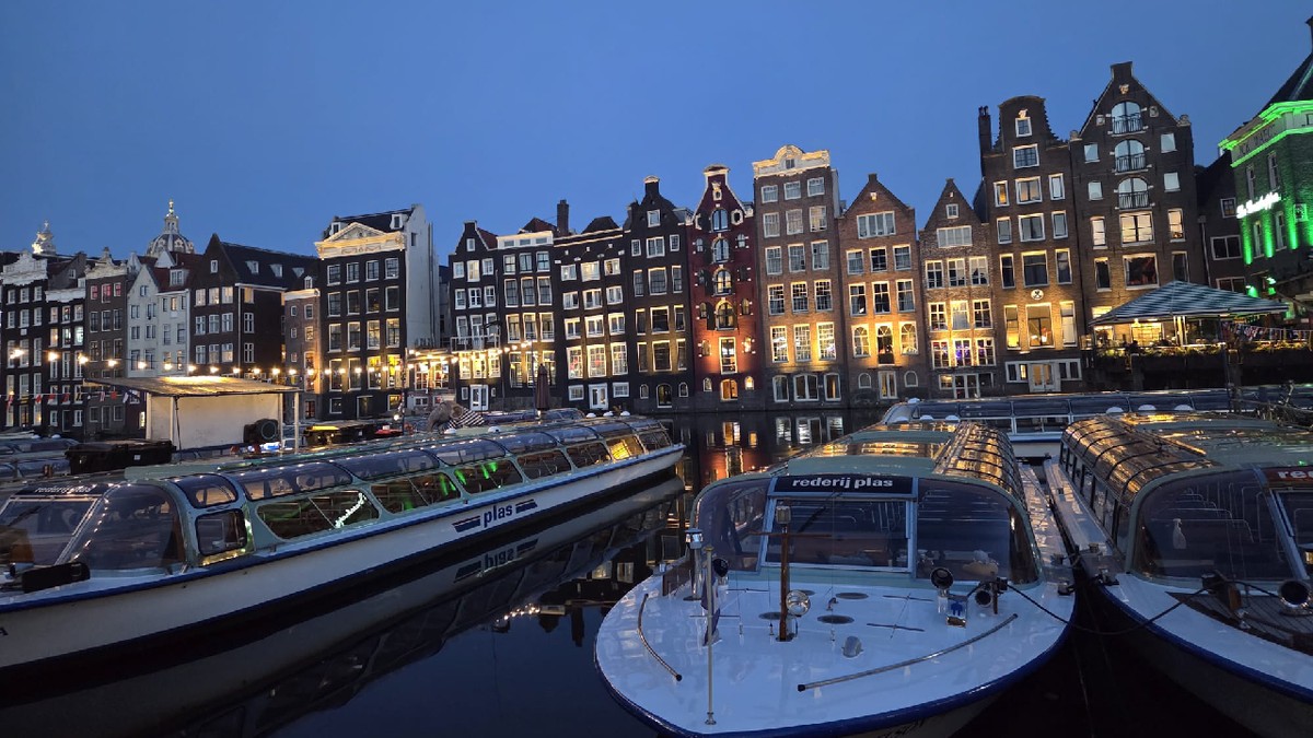 Vedere de seara a vaselor de pe canalul din Amsterdam