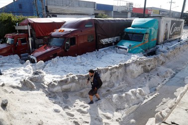 Un bărbat mergând pe străzile din Guadalajara, Jalisco, Mexico. În unele cazuri, gheața a intrat în case prin rețeaua de canalizare. EPA-EFE/Francisco Guasco
