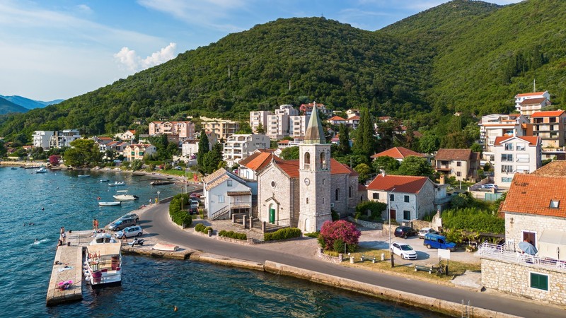 Vedere aeriana bisericii ortodoxe de pe malul apei sfantul roch de donja lastva din Tivat în golful Kotor