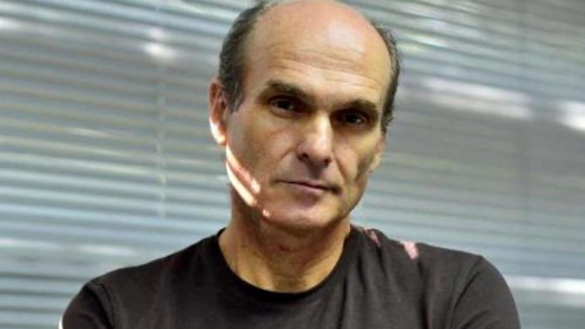 C.T. Popescu despre gestul lui Iordache din Parlament. Cristian Tudor Popescu, sobru, cu un tricou negru. În fundal sunt niște jaluzele albe