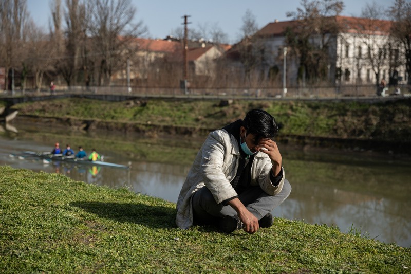 Un solicitant de azil din Afganistan așteaptă pe malul Begăi.&nbsp;