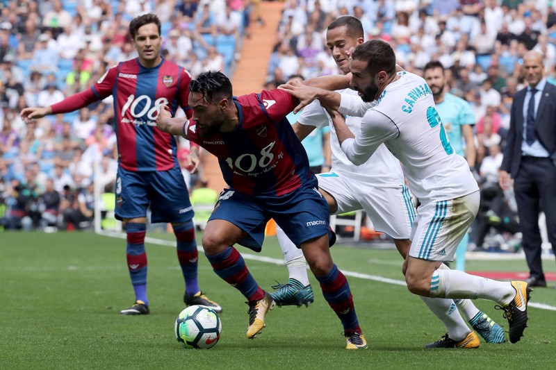 epa06193874 Real Madrid's defender Dani Carvajal (R) vies for the ball against Levante UD's Ivan Lopez (C) during the Spanish Primera Division League soccer match between Real Madrid and Levante UD at the Santiago Bernabeu stadium in Madrid, Spain, 09 September 2017. EPA-EFE/KIKO HUESCA