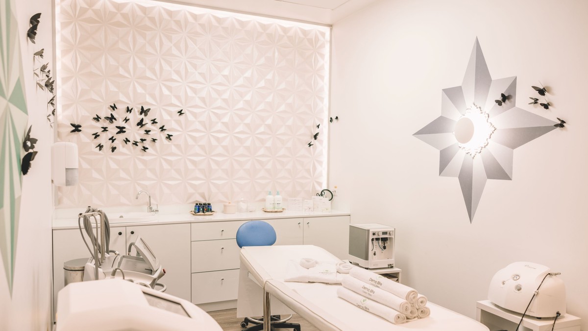 Clinica estetica - poza cu un cabinet de estetica, avand un pat in mijloc, fiind vopsit totul alb si luminos