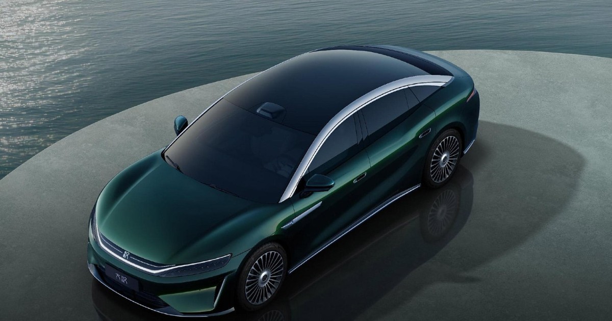 Imaginea prezintă un sedan BYD de culoare verde-închis, parcat pe o platformă circulară