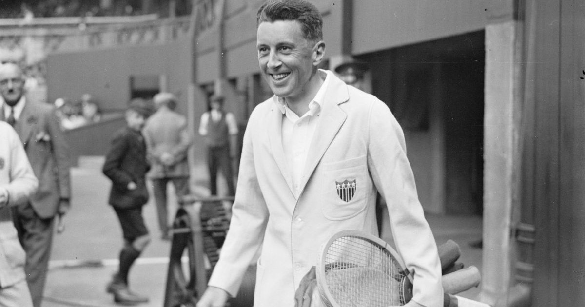 Campionul de tenis și supraviețuitor al Titanicului, R. N. Williams (Richard Norris Williams), surprins râzând și cu rachete de tenis în mână, într-o poză alb-negru, iar în spatele său se văd alți oameni, 1924