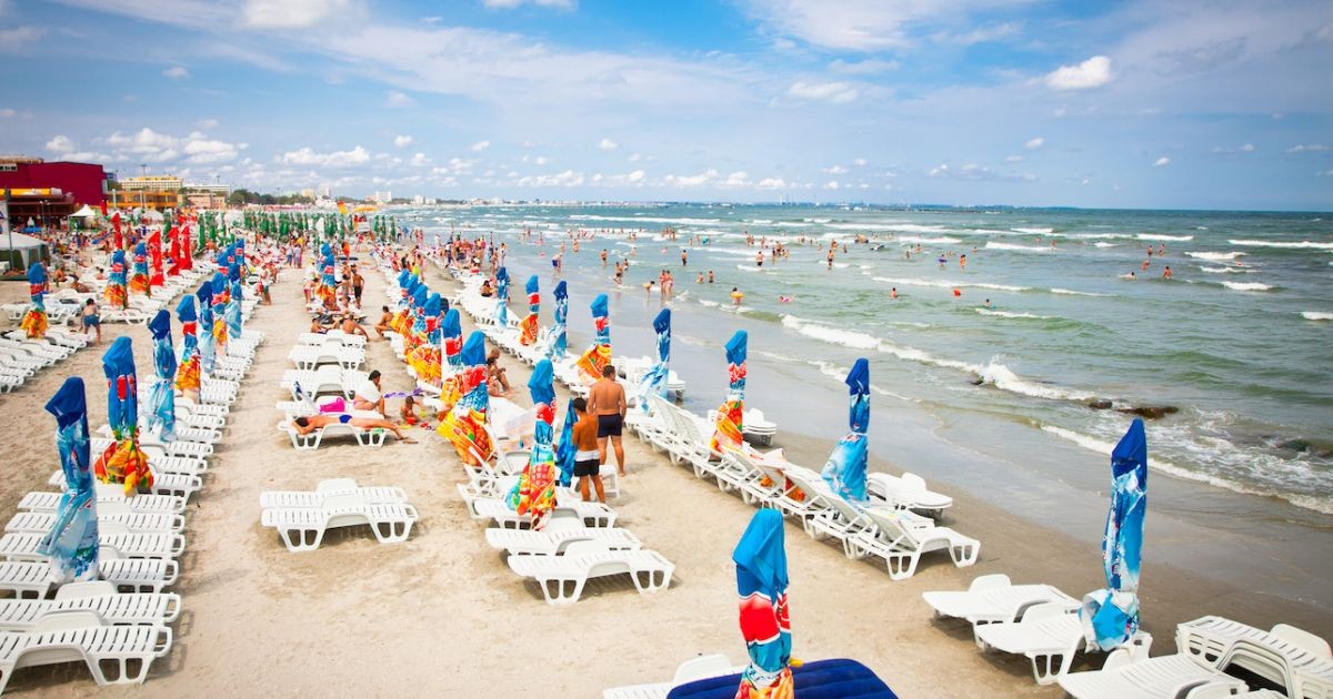 O plajă din Mamaia, România, cu umbreluțe și șezlonguri, iar oameni se văd în mare, 11 august 2012