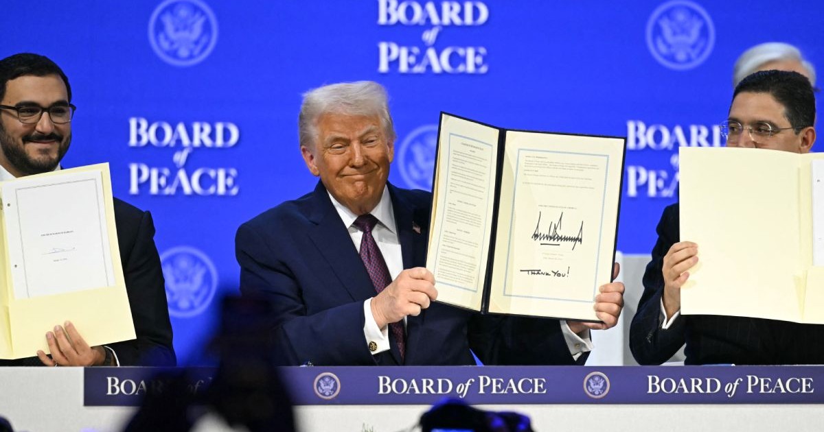 Donald Trump ține în mână Carta Consiliului pentru Pace, la Davos, pe 22 ianuarie 2026, pe fundal albastru cu numele Board of Peace
