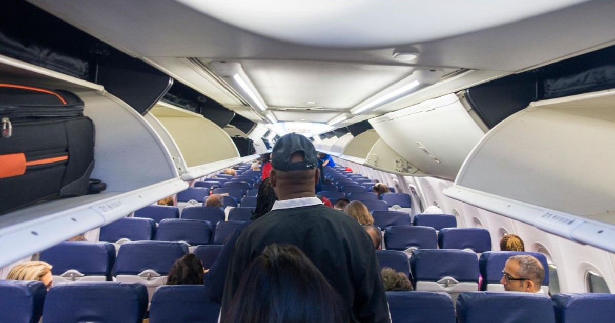 Pasageri in avion mergand spre locurile lor inainte de decolare