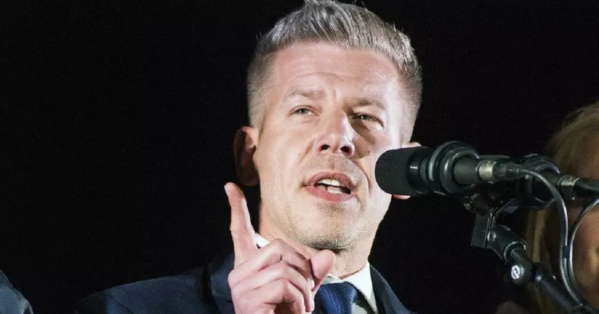 Péter Magyar, în fața unui microfon, pe fundal negru