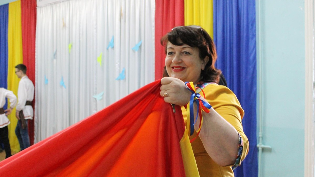 Profesor la școala românească din Tiraspol. Raisa Pădurean, ținând o pânză tricolor mare în mână
