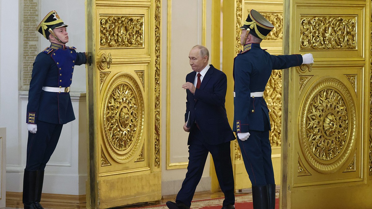 Președintele rus Vladimir Putin intră în Sala Sfântului Gheorghe a Marelui Palat al Kremlinului în timp ce două gărzi țin ușile deschise.
