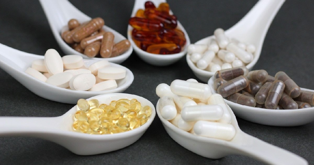 șapte lingurițe cu diferite pastile - suplimente alimentare, de forme și culori diferite