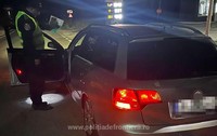 Un polițist de frontieră verifică actele unui șofer, noaptea, usa soferului este deschisă