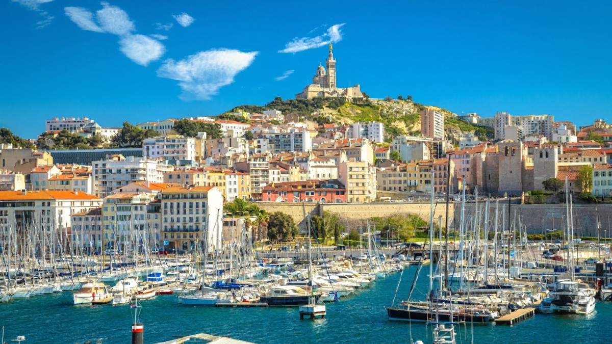 Portul orașului Marsilia și biserica Notre Dame de la Garde pe deal, sudul Franței