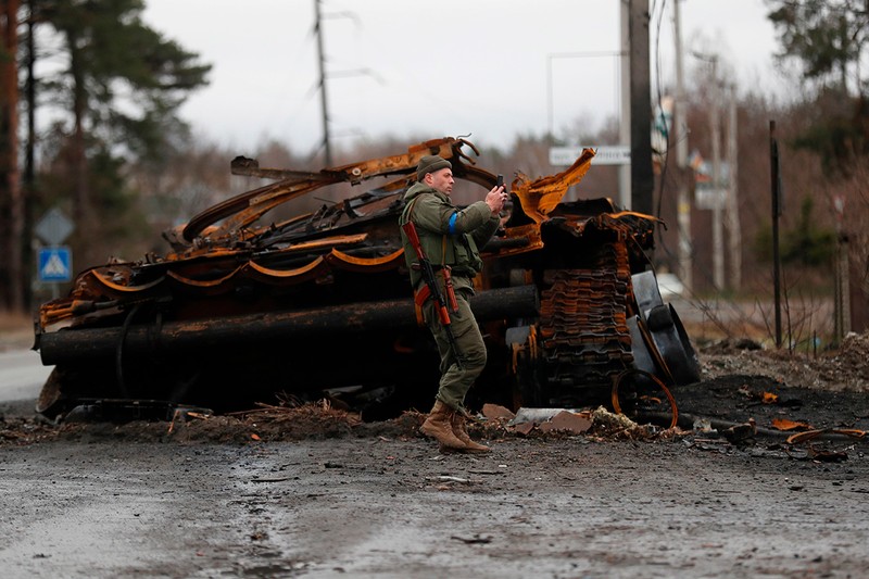 Militari ucraineni făcând fotografie lângă un tanc rusesc ars în apropierea orașului Irpin. Foto: Profimedia