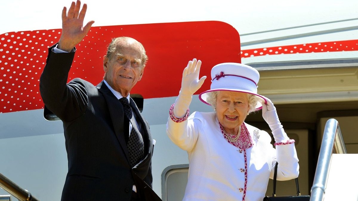 Regina Elisabeta a IIa și Prințul Philip, înainte de a intra într-un avion, făcând cu mâna
