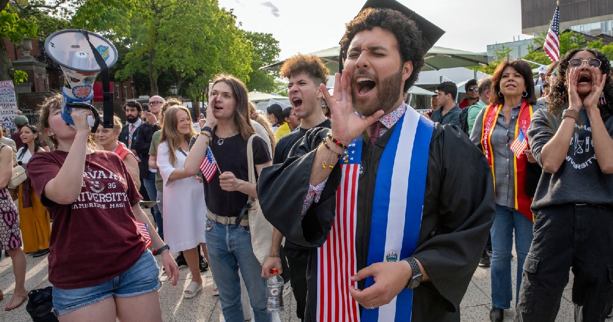 studenți Harvard în timp ce se bucură de absolvire, unul dintre ei, aflat în centrul imaginii surâde în timp ce strigă ceva