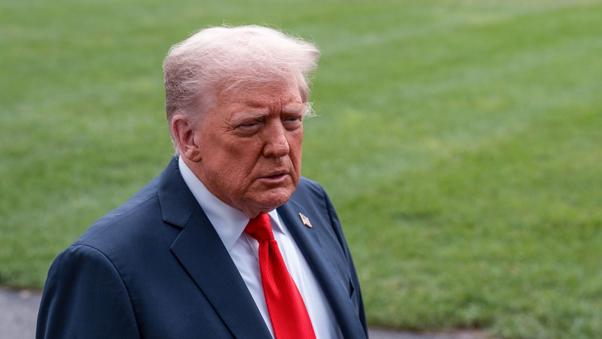 Donald Trump surprins în timp ce poartă un sacou albastru închis, o cămașă albă și o cravată roșie